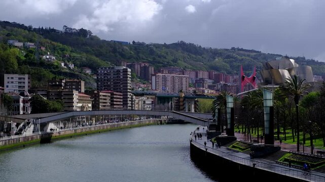 A panoramic highangle view of Bilbao, Spain, featuring the Nervion River flowing through the city center