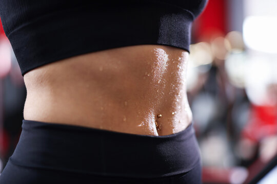 Athletic woman with sweat on her body after training in gym, closeup