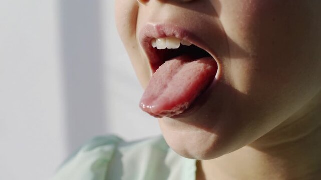 Child sticking out tongue in extreme close up shot showing dental health and mouth anatomy