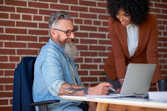 Review, manager or people in office with laptop, trend research or feedback on marketing pitch. Advice, director or creative assistant with tech, advertisement insight or proposal for brand campaign.