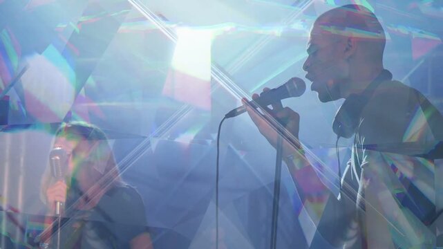 Male and female vocalists stepping to microphone, singing and dueting amid prism concert lights