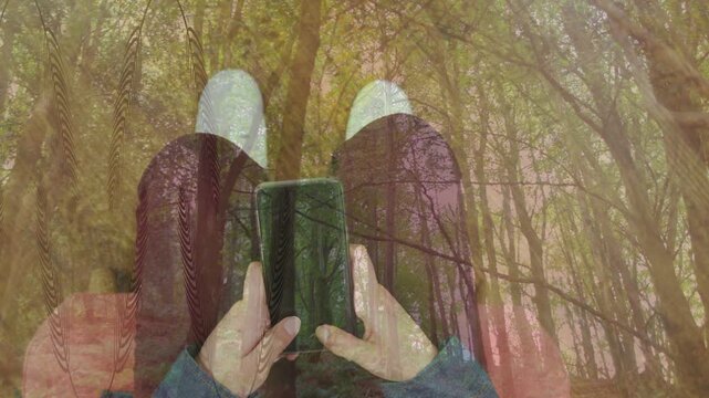Woman sitting tapping phone screen, testing nature app, forest overlay blending across lap for tech