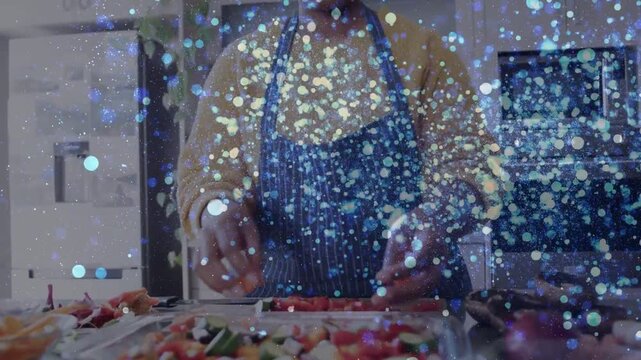 Female cook reaching for vegetables, prepping trays in kitchen, sparkly overlay obscuring parts