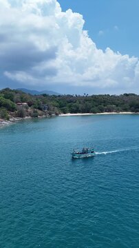 Sailboat Glides Peacefully on Vast Blue Sea with Distant Island and Hills Under Clear Sky, Evoking Tranquility on Ocean Horizon	