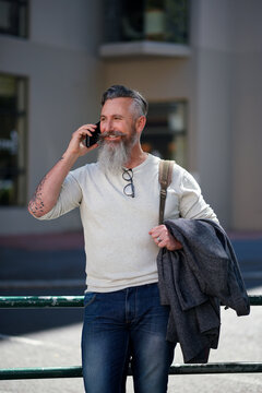 Mature, man and phone call in city for communication, happy chat or catchup with contact on trip. Male person, technology and smile with conversation on walk in street, network and travel in town