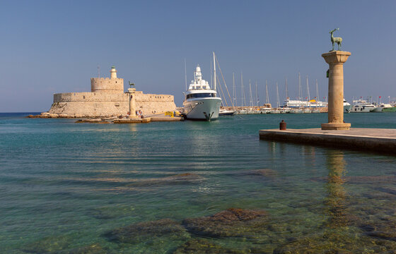 Mandraki harbor entrance with fortress and deer columns in Rhodes Greece