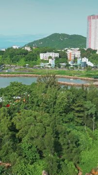 Vietnam's national flag and Buddhist flag fly on a lush green island of Chua Tu Ton overlooking the city of Nha Trang, Vietnam. The flags symbolize national pride and spiritual heritage