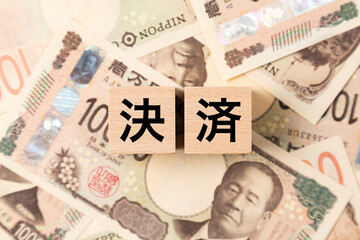 Fototapeta premium 「決済」と書かれたブロックとたくさんの一万円札