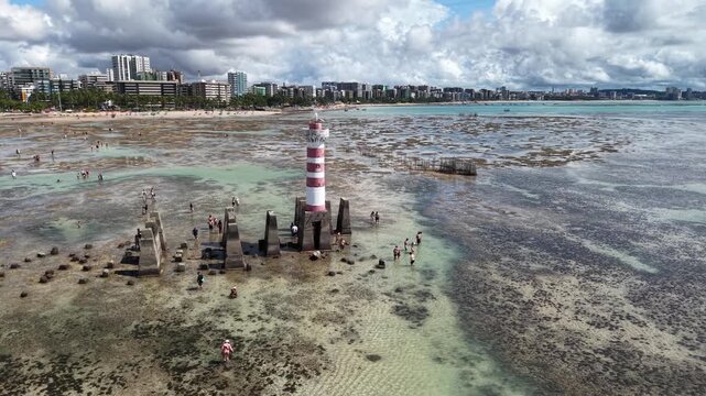 At low tide, the Ponta Verde Lighthouse reveals a unique landscape, surrounded by reefs and shallow waters that allow visitors to walk out into the sea in Macei&oacute;.- Alagoas, Brazil