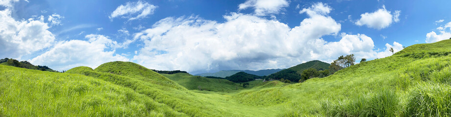 新緑の丘陵草原と青空に広がる雲のパノラマ風景 © skyhigh.ring