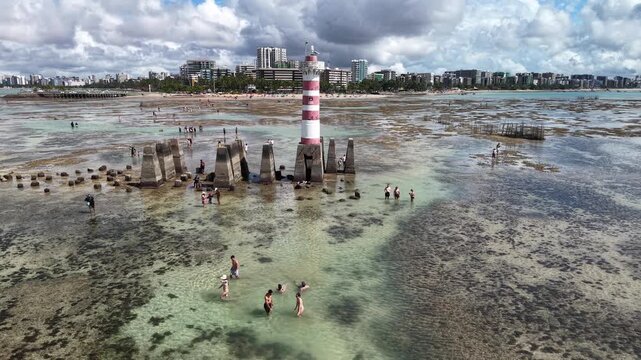 At low tide, the Ponta Verde Lighthouse reveals a unique landscape, surrounded by reefs and shallow waters that allow visitors to walk out into the sea in Macei&oacute;.- Alagoas, Brazil
