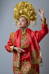 Naklejka premium Young Bride Wearing Ornate Golden Headdress And Red Traditional Wedding Costume Portrait In Studio