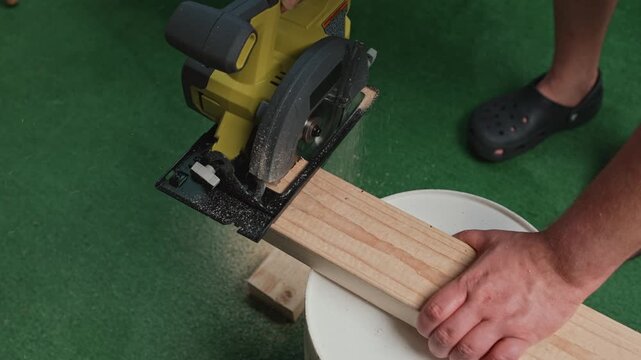 Man cutting wooden board with circular saw during construction work creating process of precise material processing and carpentry tasks using power tool