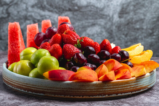 fruit plate with watermelon greengage plum grape peach apricot strawberry melon and cherry
