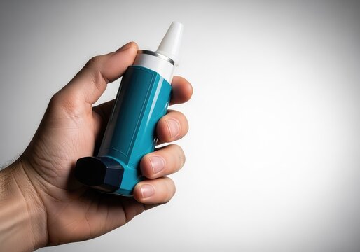 A detailed close-up view showing a hand firmly holding a blue medical inhaler canister against a soft neutral background for respiratory care, wellness, canister, wheezing
