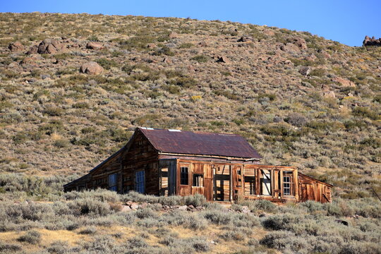 Abandoned Desert Homestead Beneath Rocky Hillside
