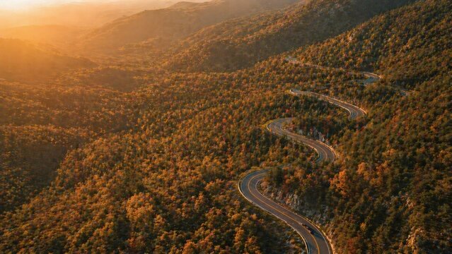 Aerial autumn switchback road with moving car motion blur