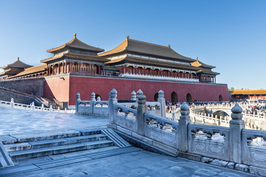 View of China Forbidden City South gate compound during sunrise with distant and blurry unrecognizable tourists crowd