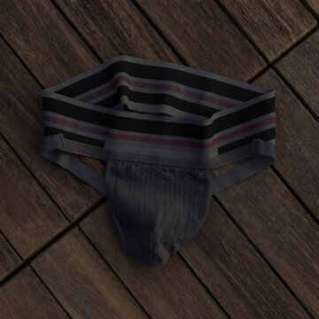Detailed close-up of a dark gray jockstrap with striped waistband resting on a rustic wooden surface