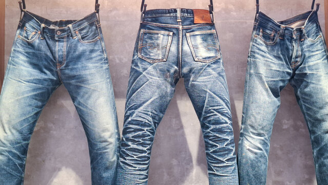 Collection of premium Piger Works raw denim jeans showing beautiful honeycomb and whisker fade patterns hanging on wall on April 27, 2026 in Bangkok, Thailand