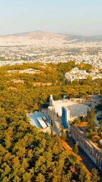 Vertical video. Athens, Greece. Odeon of Herodes Atticus - Amphitheater. Acropolis of Athens in the light of the morning sun. Summer. Drone footage, Point of interest. Rich colors