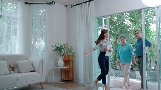 Professional real estate agent presenting property features to clients inside a modern living room during house viewing.
