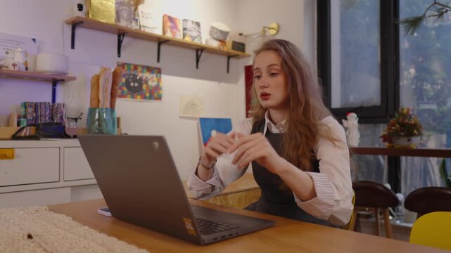 Overwhelmed young woman feeling stressed, shocked while looking at computer screen, experiencing business failure, getting a bad news, facing difficult work problem looking at her computer screen
