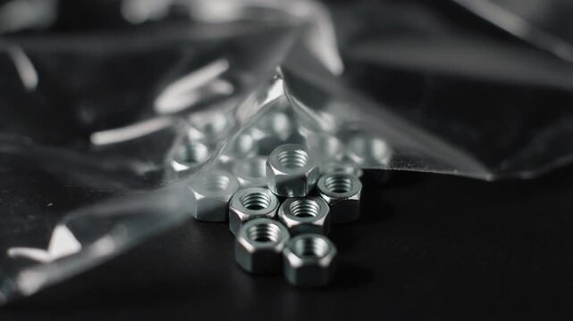 pile of metal nuts on black background