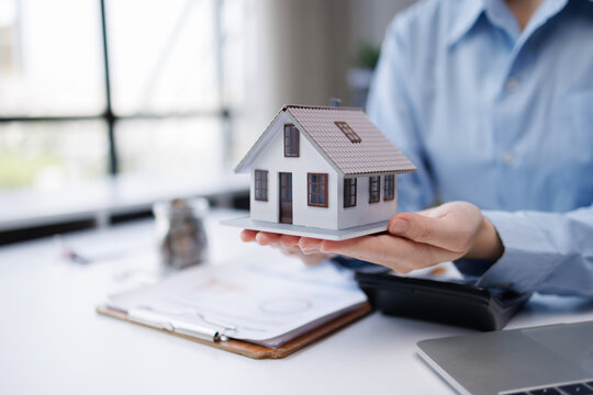 Agent holding model house offering real estate investment