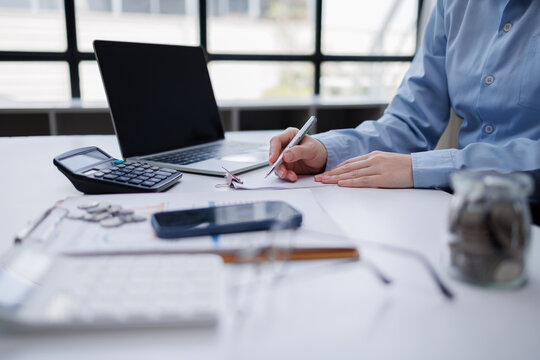 Person calculating budget and managing finances at desk