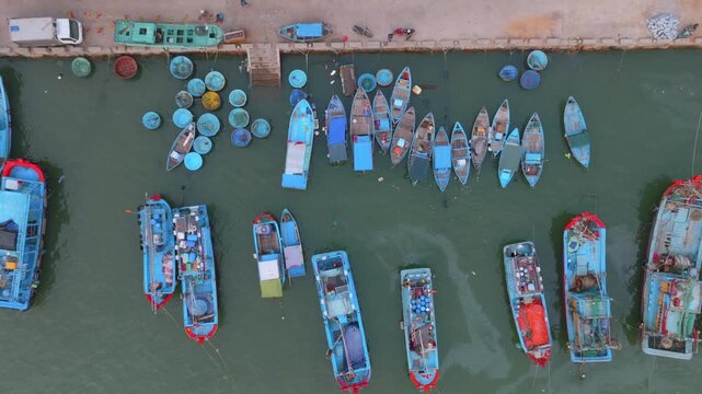 A fleet of traditional Vietnamese fishing boats and coracles are moored in a harbor in Nha Trang, Vietnam. The boats are ready for the day's catch.
