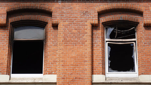 apartment or house fire damage at residential building with broken windows and burned out flat