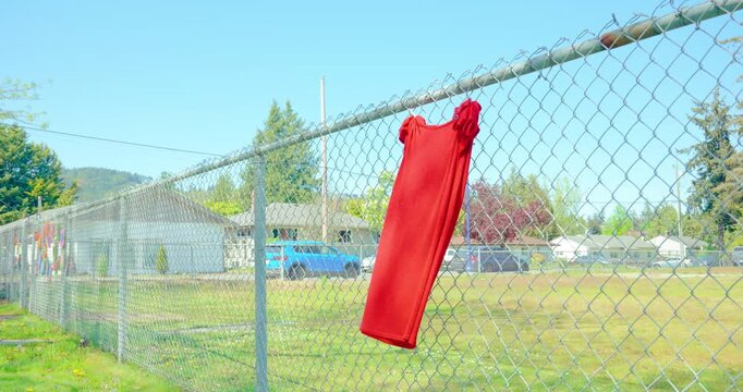 Red dress on fence for Red Dress Day MMIWG2S awareness, observed every May 5th