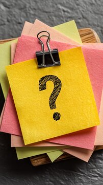 Colorful sticky notes with question mark on dark textured background