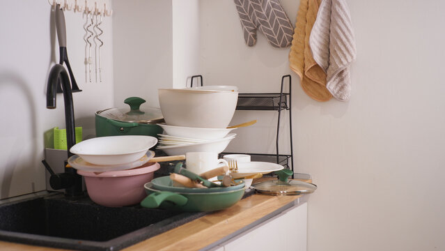 Pile of dirty dishes accumulating in kitchen sink