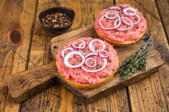 Mettbroetchen German pork sandwiches with raw minced pork spread onion rings and herbs on rustic board