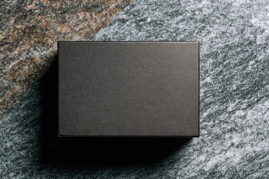 テクスチャーのある石の表面にある小さなブラックボックス