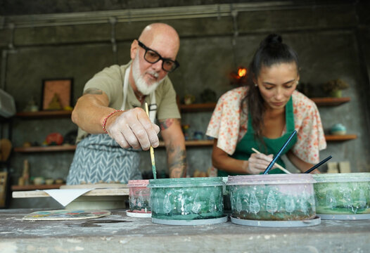 A happy couple makes ceramic plates in a workshop