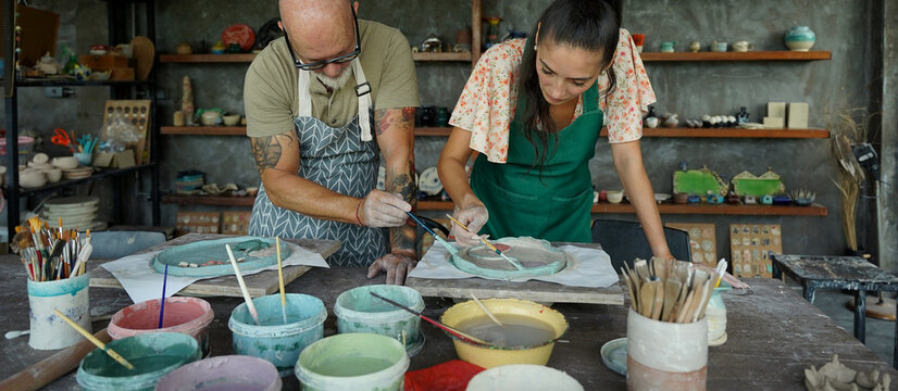 A happy couple makes ceramic plates in a workshop