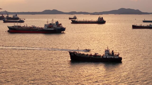 fast patrol boat with LPG gas and oil tanker ships anchored in the ocean, with a fast patrol boat in the foreground. Global energy transport, war energy crisis, and Strait of Hormuz blockade concept.	