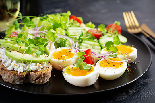 Healthy Keto Salad with Avocado and Soft Boiled Eggs on Dark Background