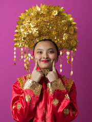 Naklejka premium Portrait of Smiling Indonesian Asian Woman in Traditional Gold Headdress and Red Festive Costume for Celebration