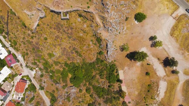 Fethiye, Turkey. Archaeological site and ruins of Fethiye Castle built by Knights of Rhodes on the hill with Turkish flag, aerial drone perspective.. Aerial View, HEAD OVER SHOT with rotation, Master
