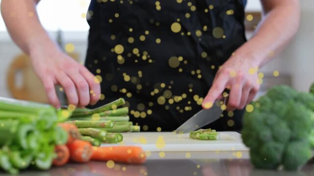 Woman cook grabbing knife, slicing asparagus at counter, preparing meal, yellow bokeh floating