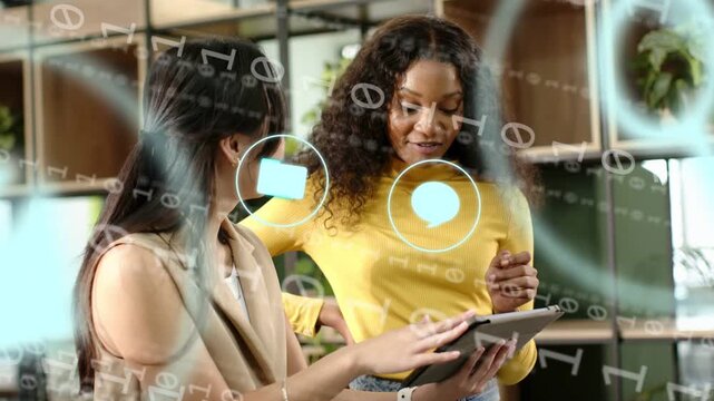 Two women tapping tablet and pointing causing overlay mail icon animating then clearing for ads