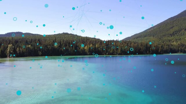 On reveal of turquoise lake, teal particles drifting and forming network over water for branding