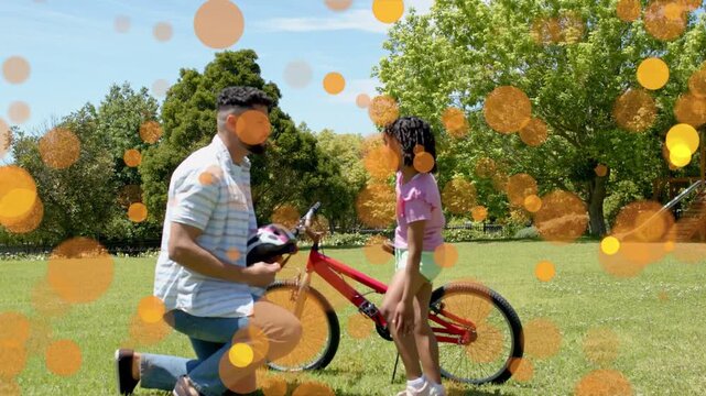 Dad reaching red bike kneeling fitting helmet buckling strap safely orange overlays moving overhead