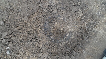 Detailed view of a crater in the ground showing soil texture and surface damage © mukolatv