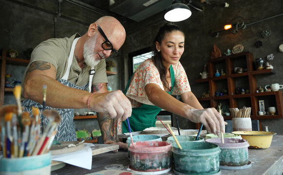 A happy couple makes ceramic plates in a workshop