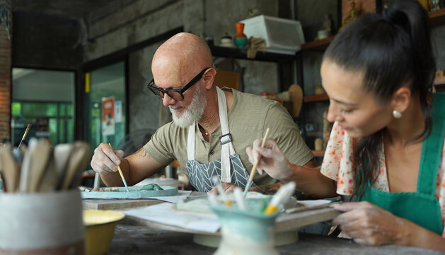 A happy couple makes ceramic plates in a workshop